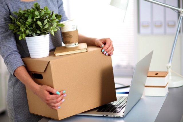 employee with moving box moving out of the office  e1608747997648 Office Moving Checklist + Corporate Relocation Guide