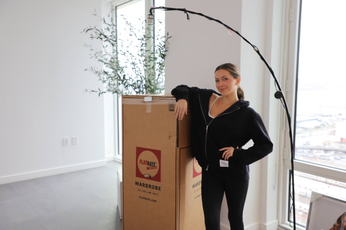 FlatRate Moving client standing next to a moving box
