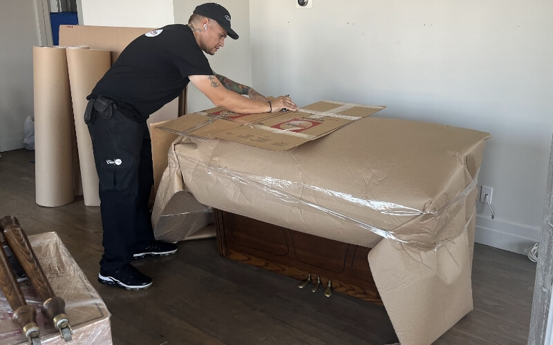 A Flatrate mover wrapping and protecting a desk with protective materials before the move
