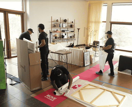 Flat rate movers carefully protecting floors as well as art